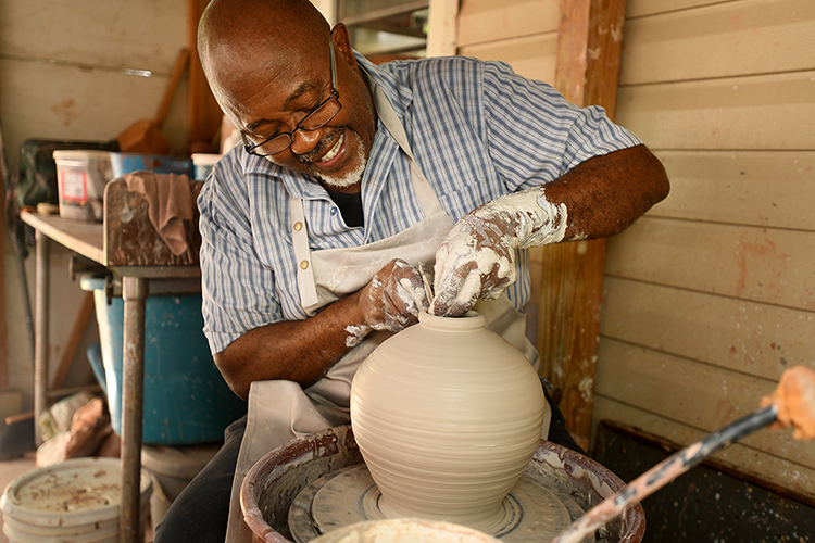 Potter at work at his pottery wheel 